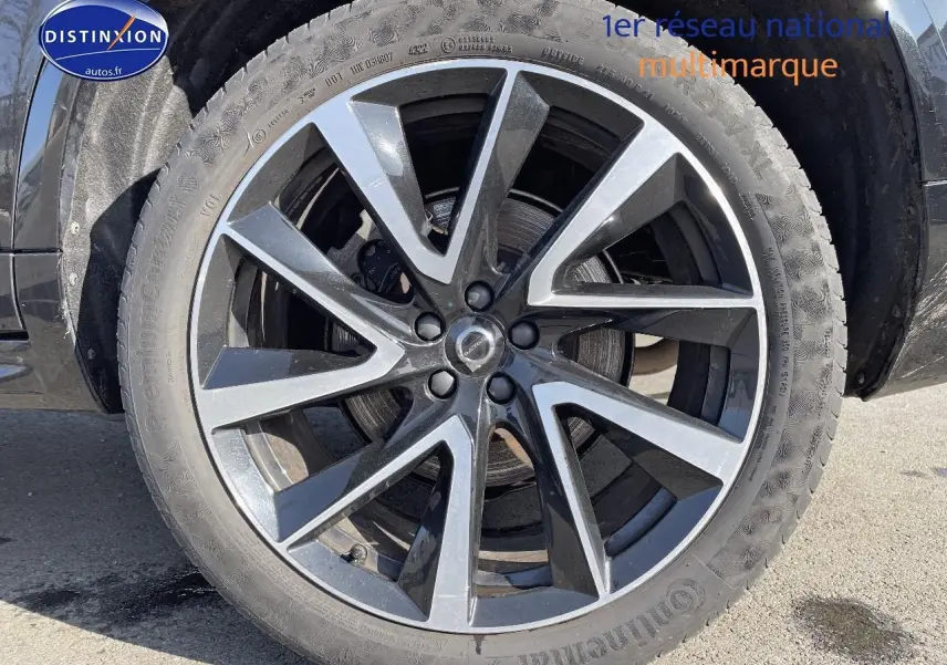 Gros plan sur la jante alu noire et argentée du côté gauche d'un Volvo XC90 noir 2023.