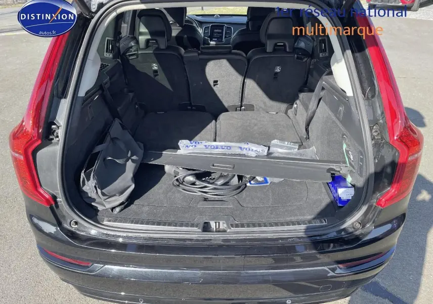 Coffre ouvert d'un Volvo XC90 noir 2023, montrant l'espace de chargement et les sièges arrière rabattus.