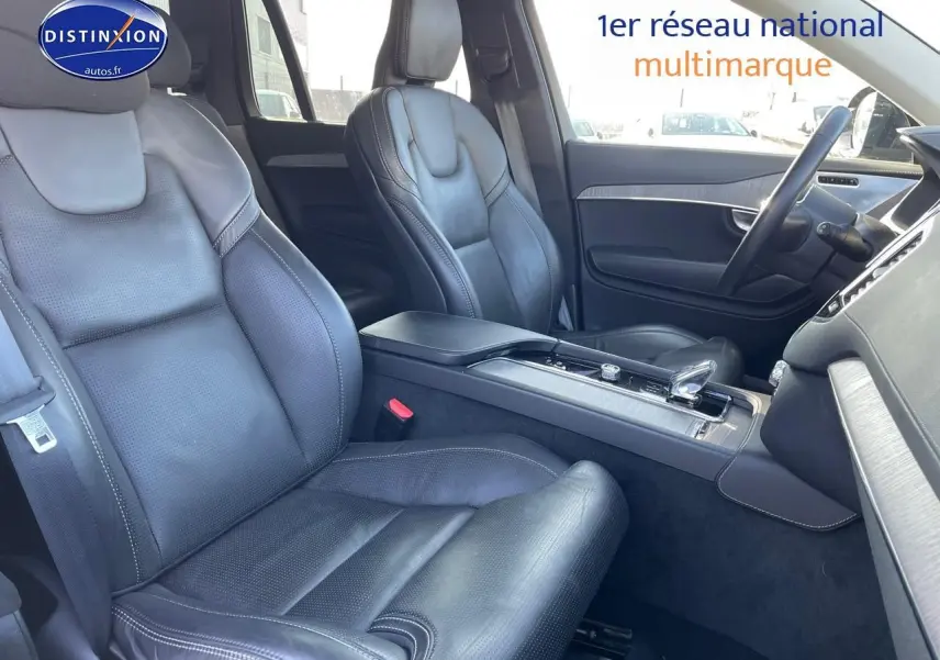 Intérieur avant du Volvo XC90 2023, sièges en cuir noir et console centrale avec levier de vitesses moderne.