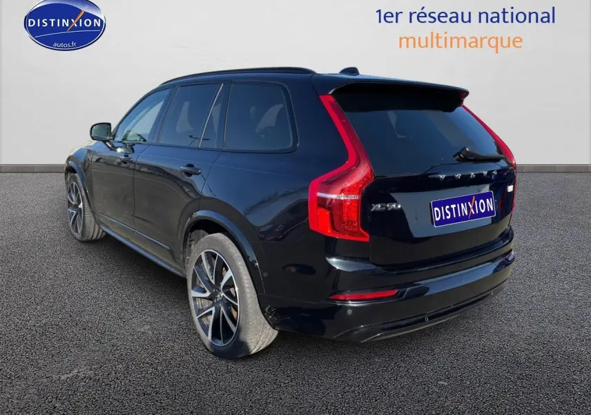 Vue 3/4 arrière droite d'un Volvo XC90 noir avec feux arrière en forme de L et jantes alliage.