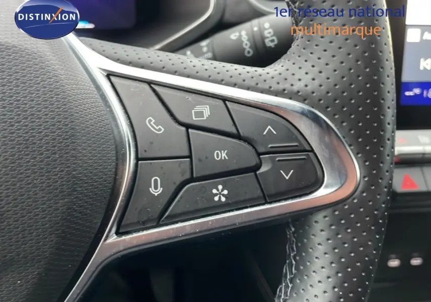 Gros plan sur les commandes multifonctions en cuir perforé du volant du Renault Symbioz noir étoile métal, version hybride 2025.