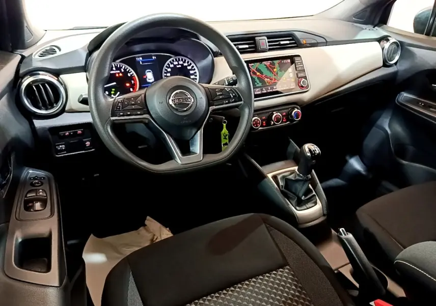 Vue intérieure avant droite du tableau de bord gris clair et noir d’une Nissan Micra IG-T 100 Business Edition avec volant multifonctions et écran tactile.