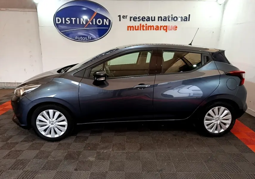 Profil droit d'une Nissan Micra IG-T 100 Business Edition gris foncé, en intérieur avec jantes alliage et rétroviseurs noirs.