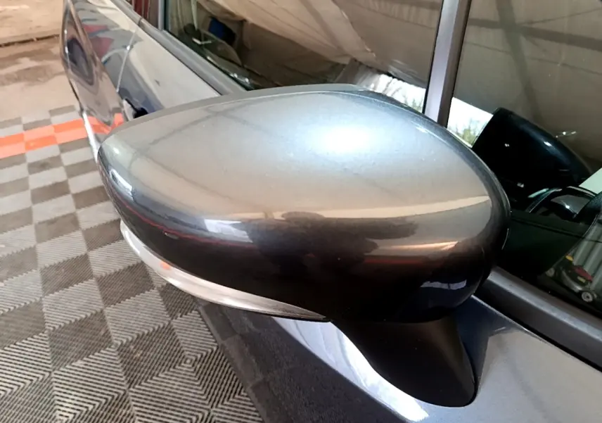 Rétroviseur extérieur gris foncé côté gauche d'une Nissan Micra IG-T 100 Business Edition 2020, avec clignotant intégré.