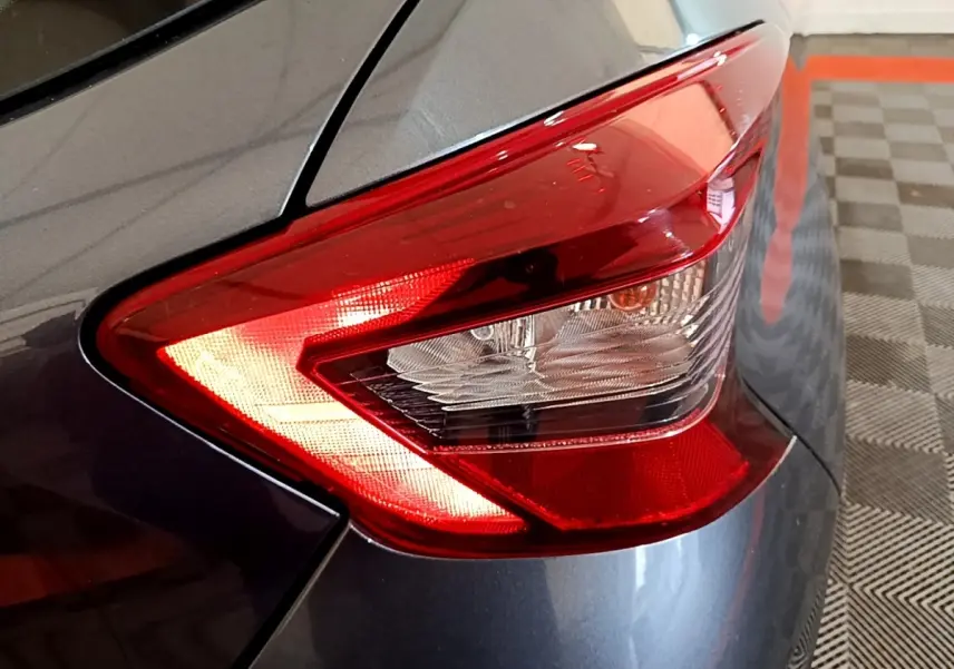 Gros plan sur le feu arrière droit rouge d'une Nissan Micra IG-T 100 Business Edition gris foncé 2020.