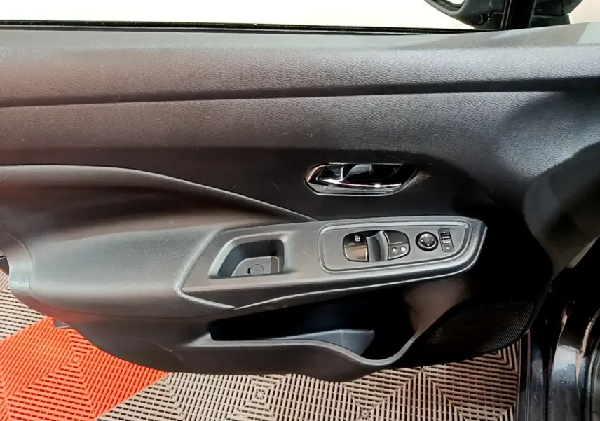 Vue rapprochée de la porte avant gauche gris foncé de la Nissan Micra avec commandes électriques des vitres et rétroviseurs.