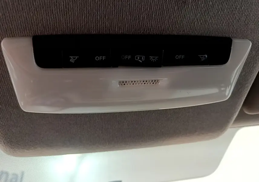 Plafonnier intérieur avec boutons de commande d’éclairage dans une Nissan Micra gris foncé, vue de dessous.