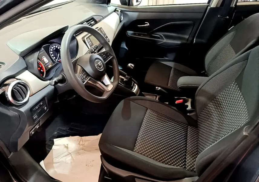 Vue intérieure côté conducteur de la Nissan Micra gris foncé 2020, volant multifonctions et sièges tissu bicolore.