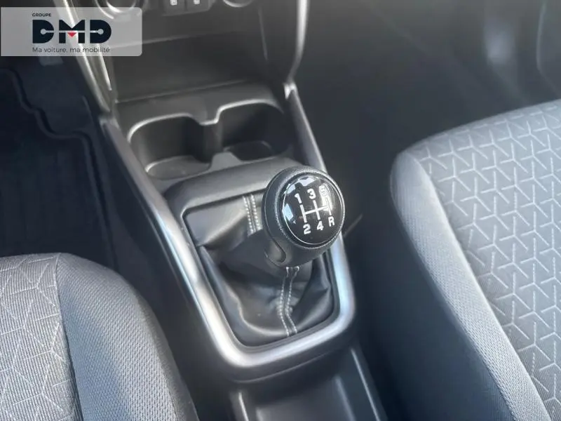 Vue rapprochée de la boîte manuelle noire et du levier de vitesses dans l'habitacle tissu gris de la Suzuki Swift 1.2 Hybrid.
