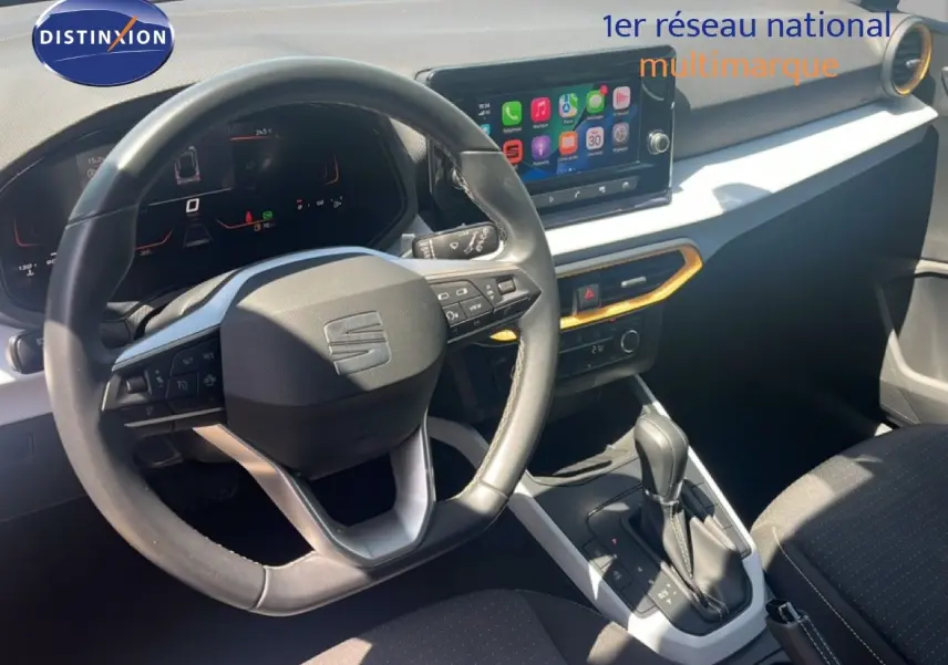 Vue intérieure centrée sur le volant et la console centrale du SEAT Arona 2025 avec écran tactile et sellerie noire.