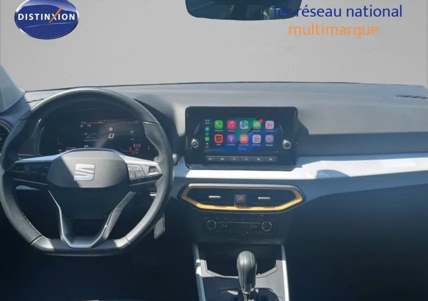 Vue intérieure frontale du tableau de bord du SEAT Arona bleu saphir, avec écran tactile et volant multifonction.