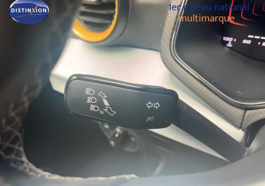 Gros plan sur la manette de clignotant côté gauche du tableau de bord du SEAT Arona 2025 bleu saphir métal avec toit noir.