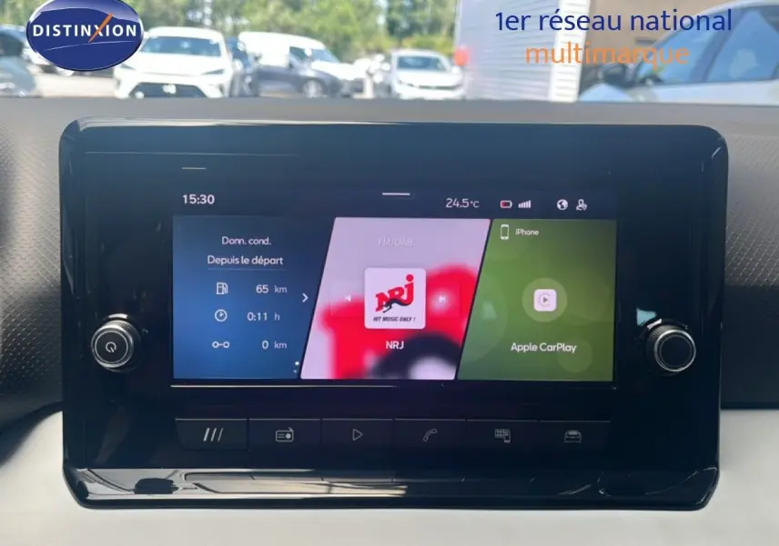 Écran tactile central du tableau de bord du SEAT Arona 2025, affichant radio NRJ et Apple CarPlay.