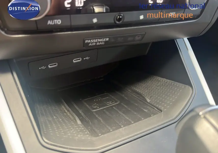 Vue rapprochée de la console centrale du SEAT Arona 2025, montrant les ports USB et le chargeur sans fil.