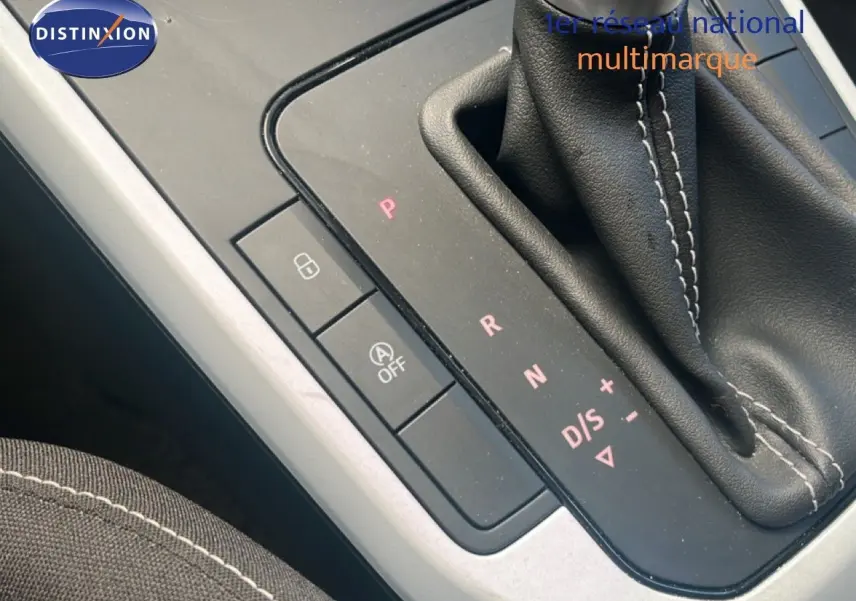 Gros plan sur la console centrale et levier de vitesses automatique du SEAT Arona bleu saphir avec surpiqûres blanches.