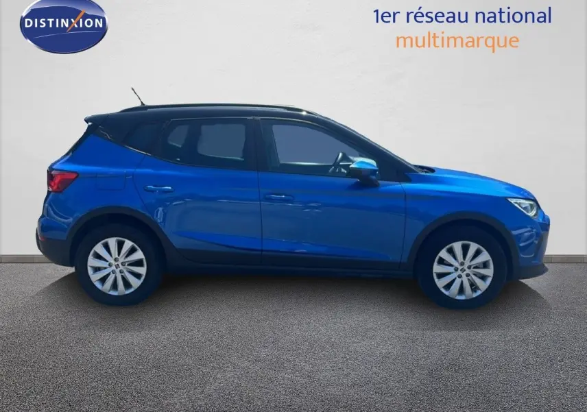 Vue latérale droite d'un SEAT Arona 2025 bleu saphir métallisé avec toit noir, roues alliage et carrosserie compacte.