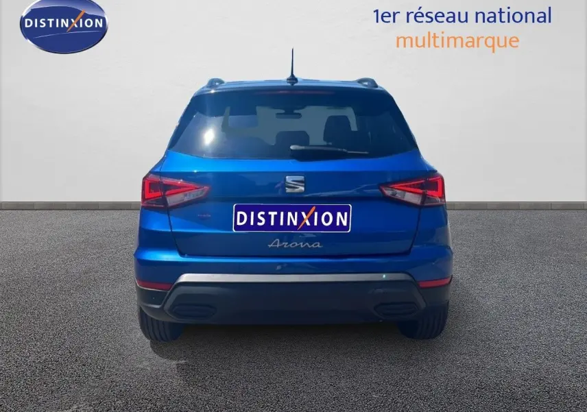 Vue arrière d’un SEAT Arona bleu saphir avec toit noir, mettant en valeur ses feux arrière LED et son design compact.