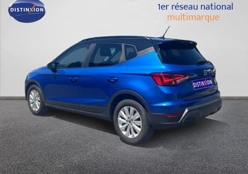 SEAT Arona bleu saphir métal avec toit noir, vue 3/4 arrière côté gauche sur fond neutre.