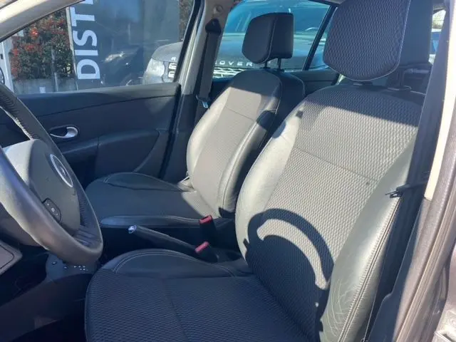 Intérieur de la Renault Clio III 110 ch 2010, vue côté gauche sur les sièges avant en tissu gris foncé.