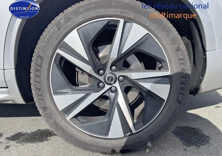 Gros plan sur la jante alu bicolore du côté avant gauche d'un Volvo XC90 gris 2022 finition R-Design.