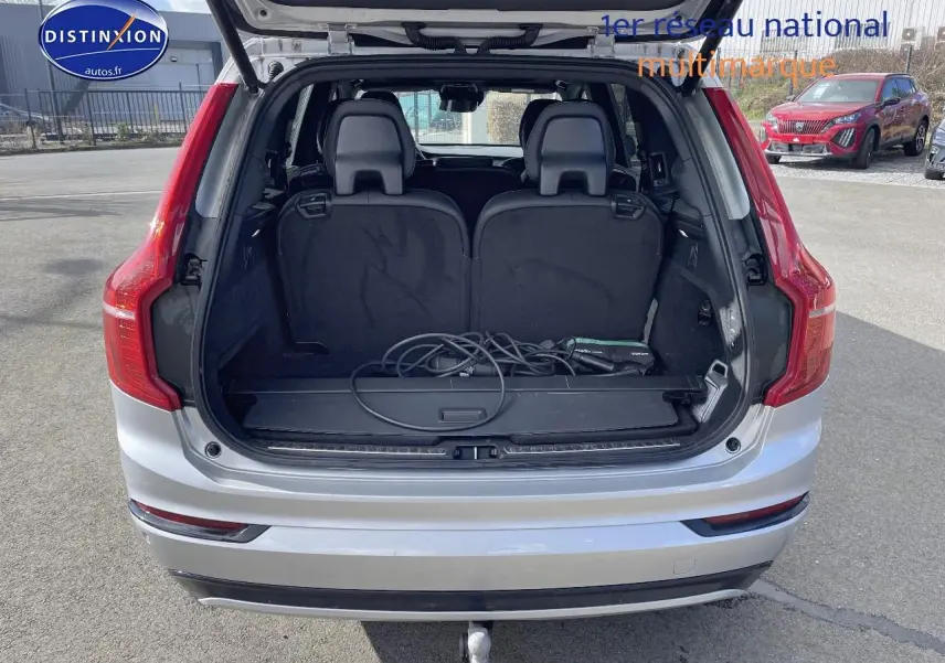 Vue arrière ouverte du Volvo XC90 gris avec coffre visible et câble de recharge posé, attelage semi-électrique apparent.