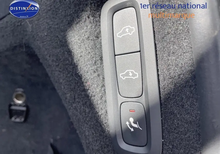 Gros plan sur les commandes d'ouverture et fermeture du coffre dans l'habitacle d'un Volvo XC90 gris.