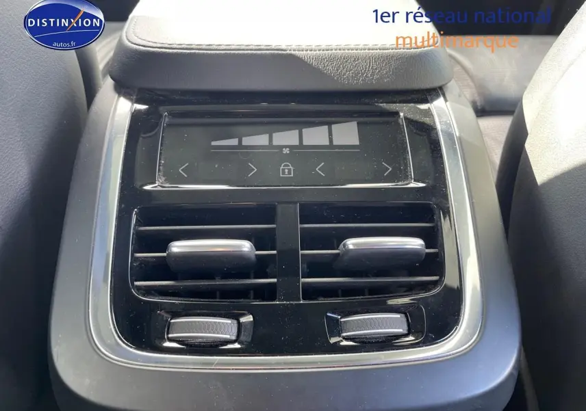 Détail de la console arrière noire avec commandes de climatisation et accoudoir du Volvo XC90 gris 2022.
