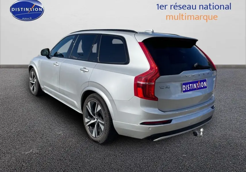 Vue 3/4 arrière droite du Volvo XC90 gris avec attelage et vitres arrière teintées sur fond neutre.
