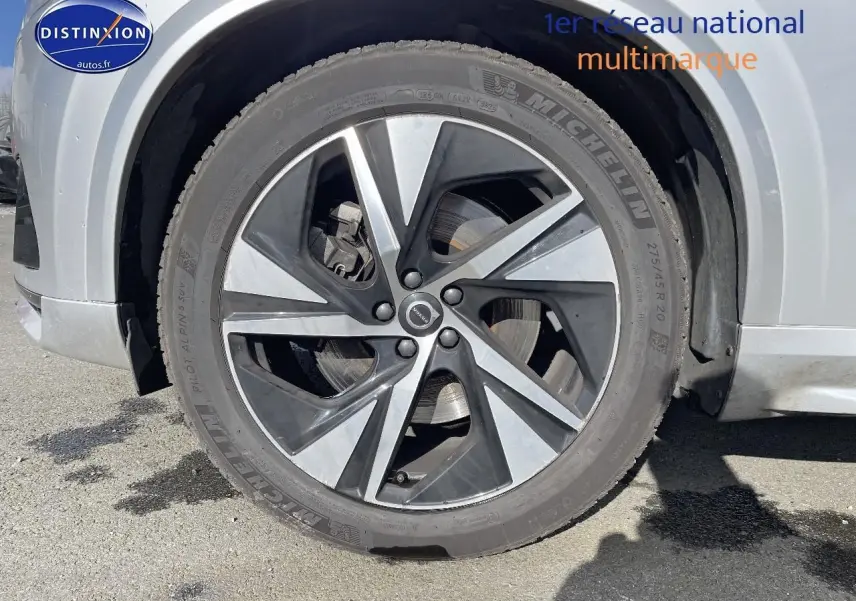 Gros plan sur la jante alu bicolore du côté avant gauche d'un Volvo XC90 gris 2022 finition R-Design.