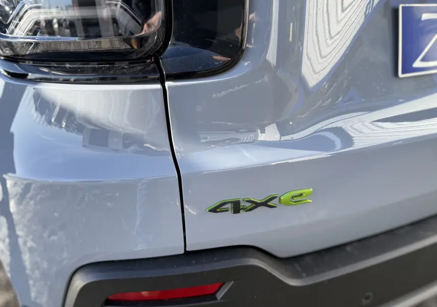Gros plan sur l'arrière droit gris Storm d'un Jeep Avenger 2025 avec logo vert 4xe soulignant l'hybridation.