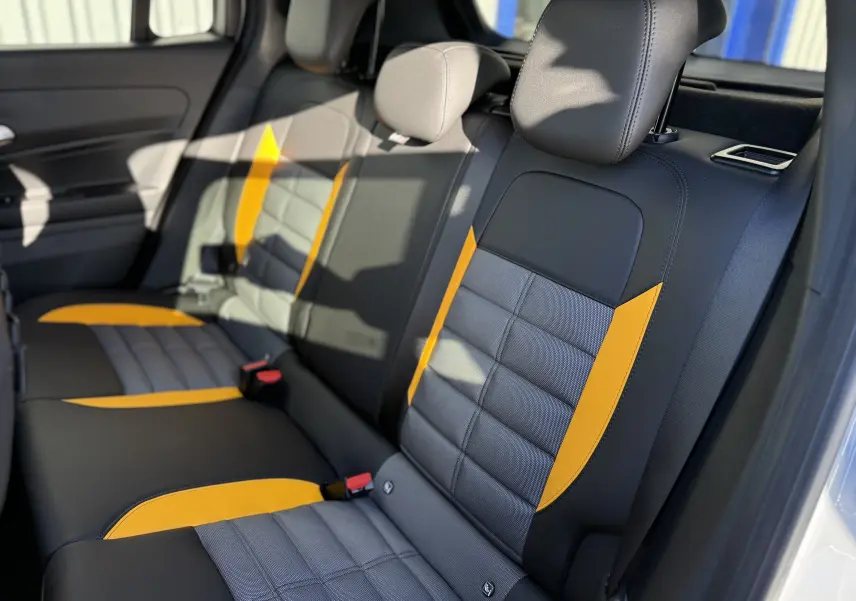 Vue intérieure côté droit des sièges arrière du Jeep Avenger 2025, avec sellerie noire et inserts jaunes contrastants.