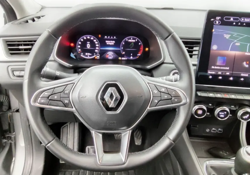 Vue intérieure centrée sur le volant noir du Renault Captur 2024 avec tableau de bord numérique et écran tactile.