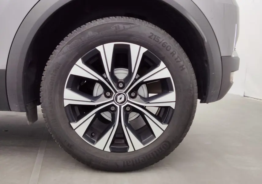 Gros plan sur la roue avant gauche du Renault Captur 2024 gris Cassiope avec jante alliage bicolore distinctive.