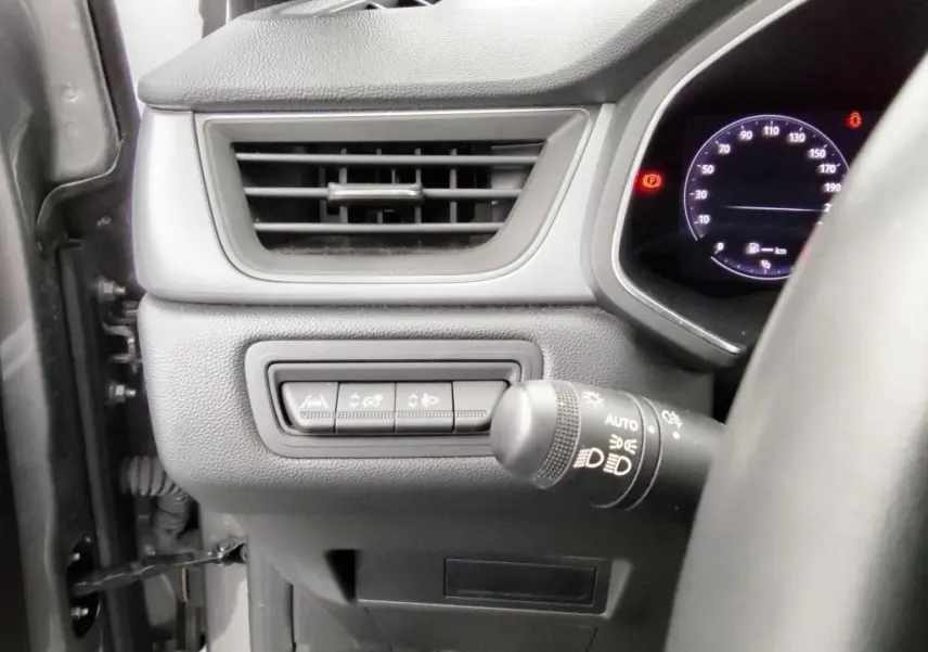 Détail intérieur côté gauche du tableau de bord du Renault Captur 2024 gris cassiope, avec commandes d'assistance et ventilation.