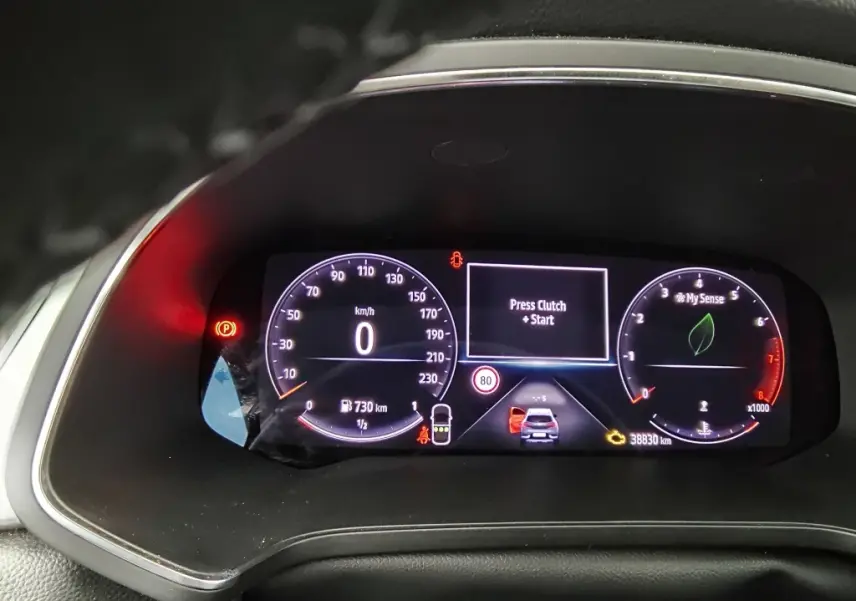 Vue rapprochée du tableau de bord numérique du Renault Captur 2024, affichant la vitesse à 0 km/h et l'invite "Press Clutch + Start".