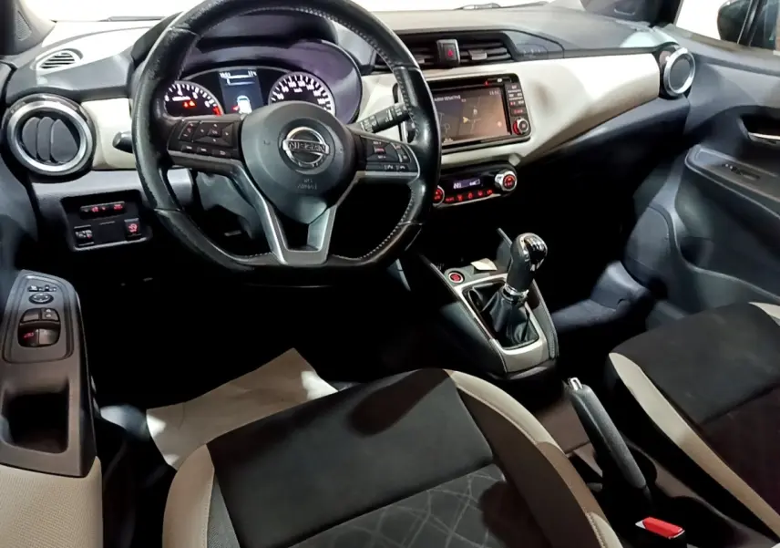 Vue intérieure avant de la Nissan Micra IG-T 90 N-Connecta 2017, volant cuir multifonctions et écran tactile central visible.