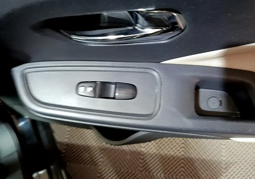 Gros plan sur la commande de réglage des rétroviseurs côté conducteur de la Nissan Micra IG-T 90 N-Connecta noire.