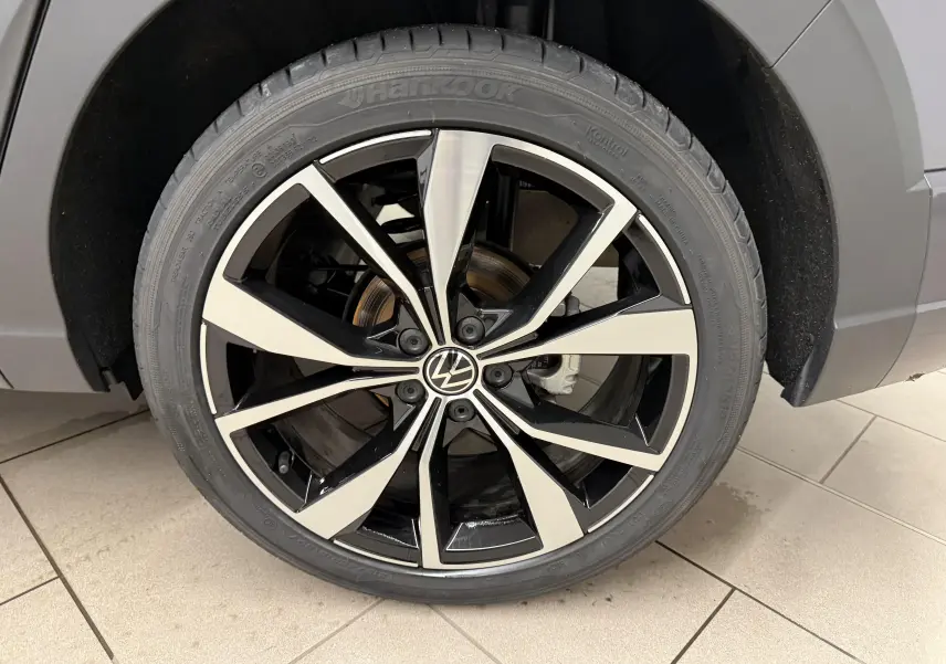 Gros plan sur la jante alliage 18 pouces bicolore noir et argent du Volkswagen Taigo gris cendre, côté arrière droit.