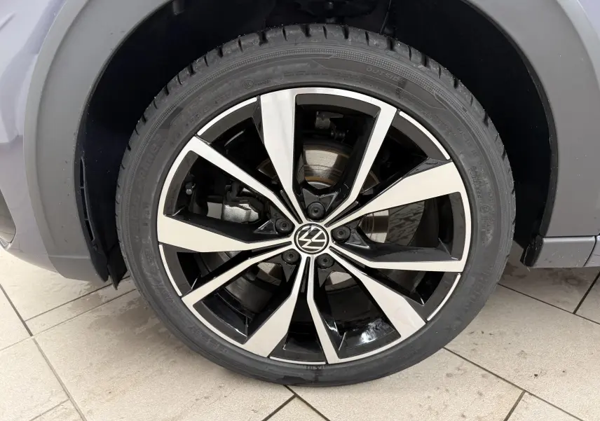 Gros plan sur la jante alliage 18 pouces bicolore noir et argent du Volkswagen Taigo gris cendre, version R-Line.
