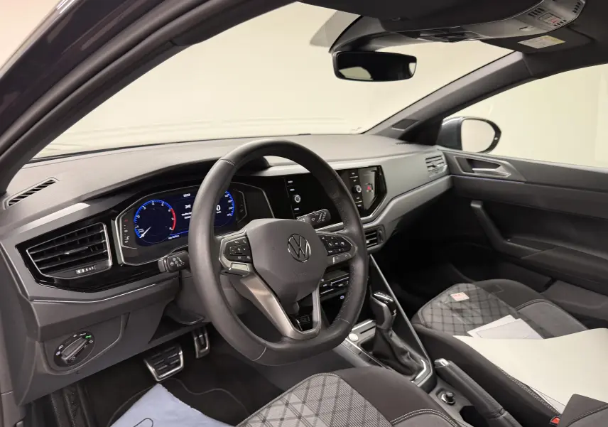 Vue intérieure côté conducteur du Volkswagen Taigo 2025, volant cuir multifonctions et tableau de bord digital.