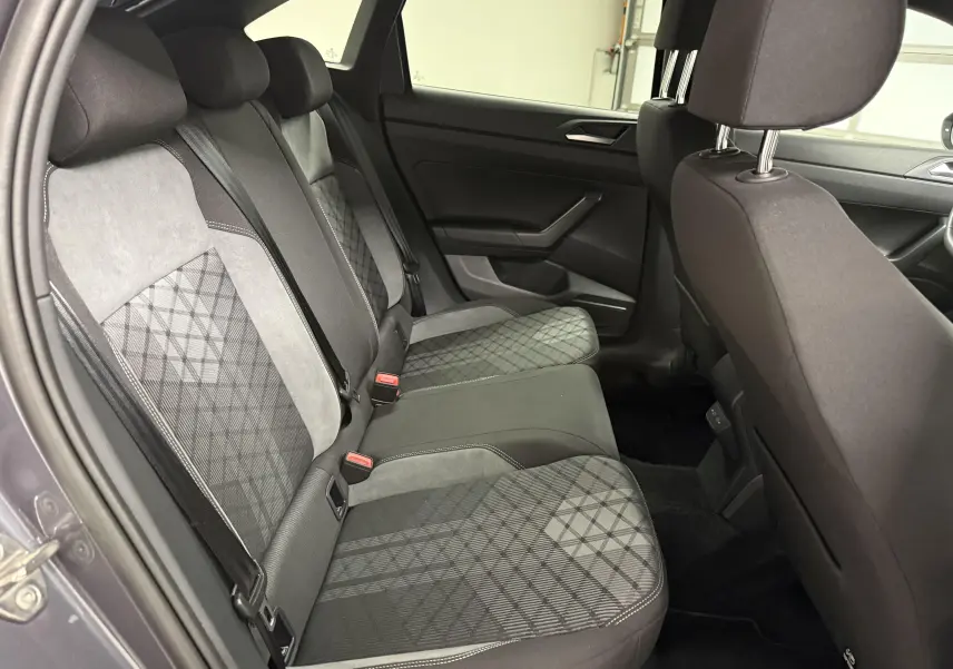 Vue intérieure de la banquette arrière du Volkswagen Taigo gris cendre, avec sièges tissu à motifs géométriques.