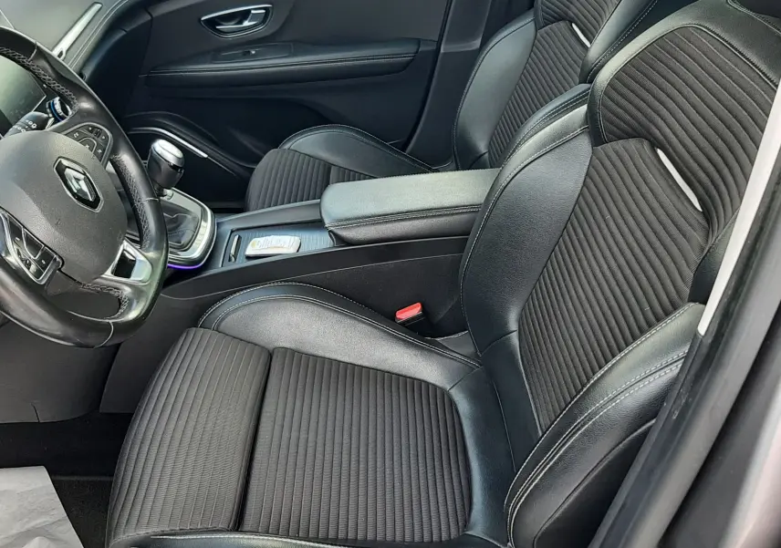 Vue intérieure du poste de conduite du Renault Scénic IV 1.7 Blue dCi, volant cuir noir et console centrale avec boîte manuelle.