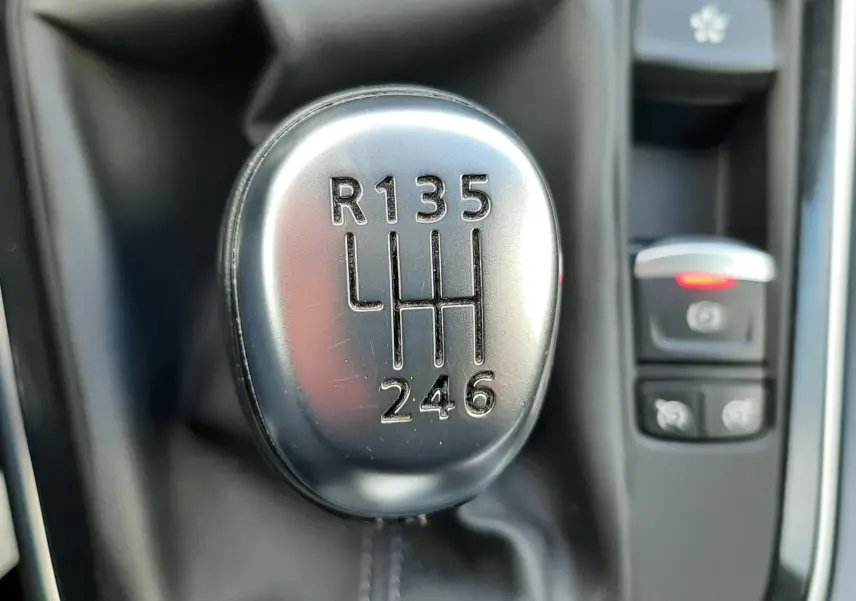 Gros plan sur les commandes de frein à main électrique et régulateur de vitesse du Renault Scenic IV gris Cassiopée.