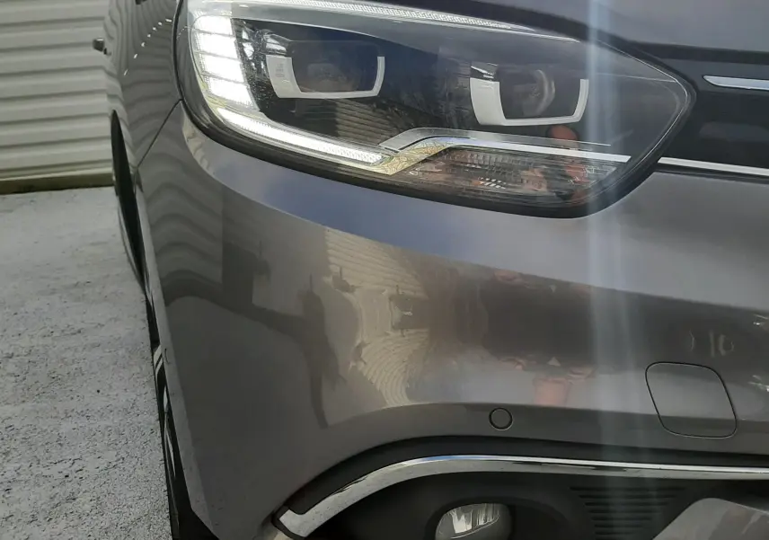 Gros plan sur l’écusson Bose sur la porte gris cassiopée d’un Renault Scénic IV 2020, finition Intens.