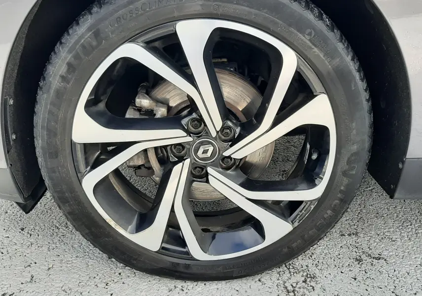 Gros plan sur le phare avant gauche du Renault Scénic IV gris Cassiopée avec toit noir, mettant en valeur les LED distinctives.