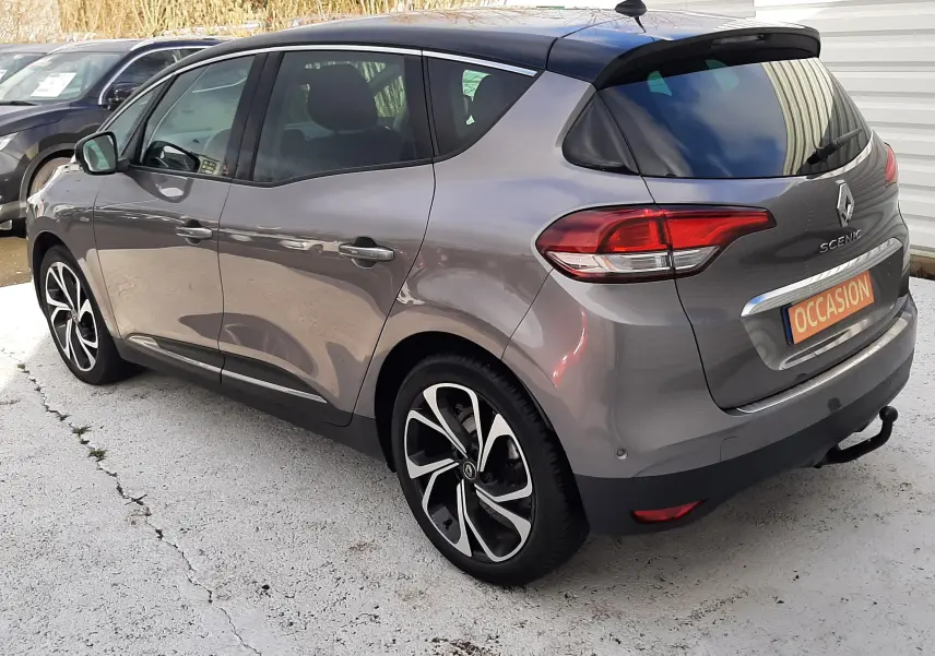 Renault Scénic IV gris Cassiopée avec toit noir, vue 3/4 arrière côté droit, jantes noires et blanches distinctives.