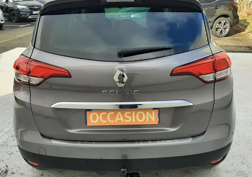 Vue 3/4 arrière droite d'un Renault Scénic IV gris Cassiopée avec toit noir et jantes alliage bicolores.