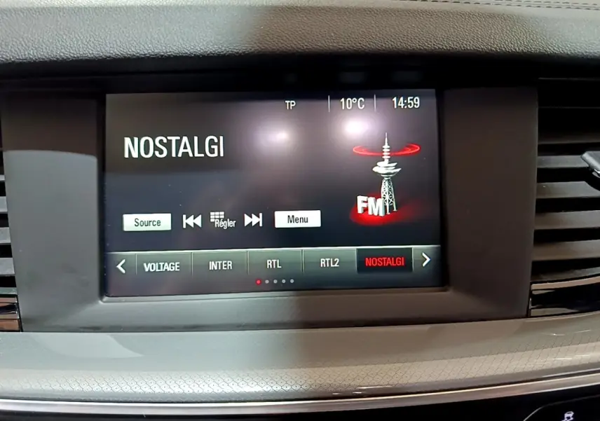 Écran tactile central de l’Opel Insignia 2019 affichant la radio FM sur fond noir, entouré de la console grise.