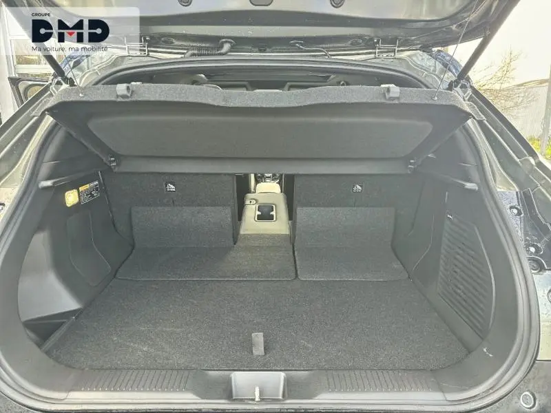 Coffre ouvert vu de l'arrière du Suzuki Vitara 2026, intérieur noir avec accoudoir central et trappe à skis.