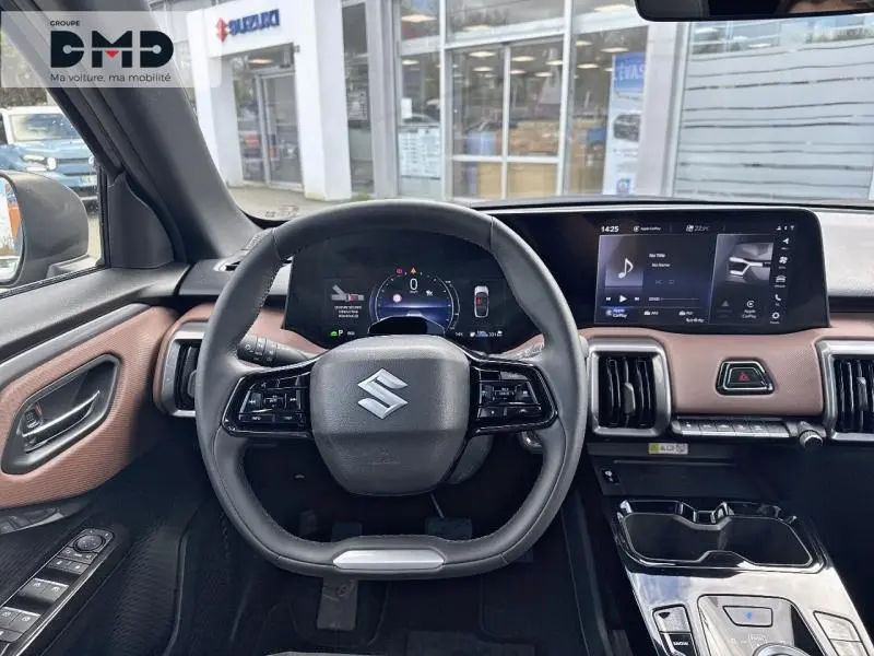 Vue intérieure centrée sur le volant et tableau de bord du Suzuki Vitara 2026 avec finition cuir noir et marron.